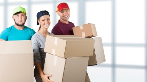 Removal team loading household items into a van